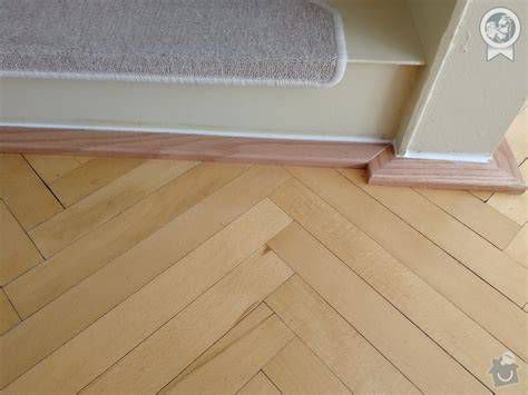 Detailný záber na tmelenie škár v drevenej parketovej podlahe