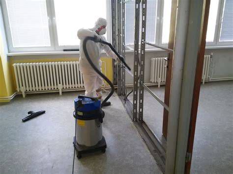 Pracovníci v ochranných oblekoch pri demontáži eternitu