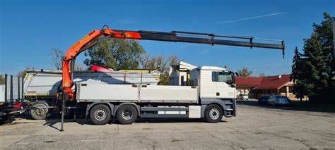Nákladné auto STAVMAT STAVEBNINY s hydraulickou rukou vykladajúce stavebný materiál